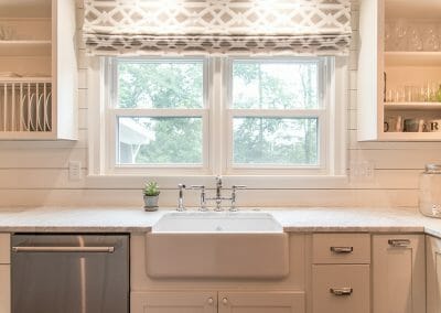 The farm sink and vintage style drawer hardware add a timeless touch to this modern farmhouse kitchen remodeling project in Atlanta