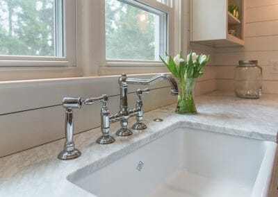 The bridge faucet on the farm sink looks like an antique, but is brand new in the kitchen remodeling project in Atlanta