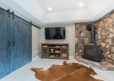 Sitting room with TV and wood stove in Roswell master suite remodel