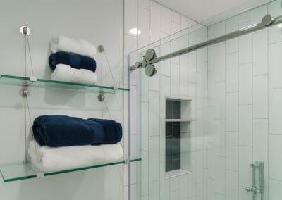 Glass shelving for towels in the Roswell master suite remodeling project
