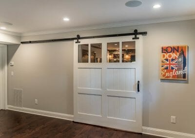 The barn door separates the bar and home theater in entertainment space in East Cobb