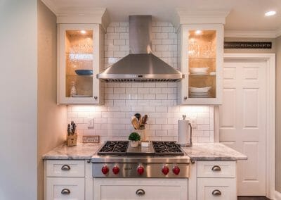Cooktop, vent hood, cabinetry and subway tile backsplash in East Cobb kitchen remodeling