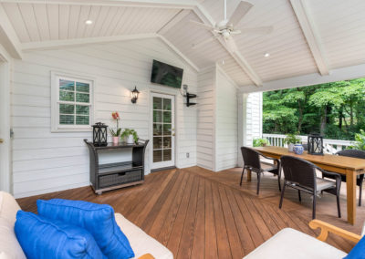 Porch renovation with view of how roof ties into house, with crowned corner posts, vaulted tongue and groove ceiling, recessed lighting, exposed beams, and outdoor TV hookup..