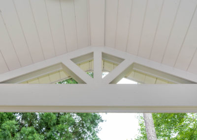 Porch renovation detail of gable pediment design, tongue and groove vaulted ceiling, and beam.