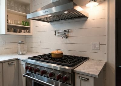 Wolf range and vent hood with pot-filler faucet in this kitchen renovation in Atlanta