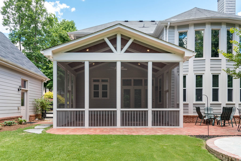 Porch renovation with view from yard (centered), with 15 foot height, vaulted ceiling with recessed lights, custom screens, and gable pediment design on existing brick patio.