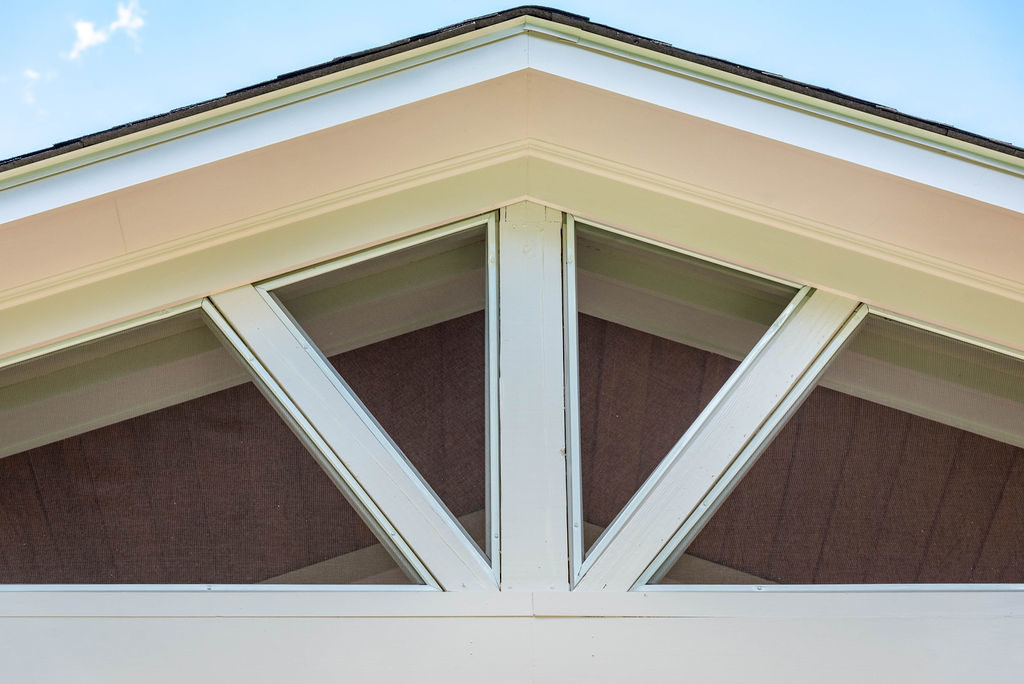 Porch renovation detail of trim work and custom screening for gable pediment design.