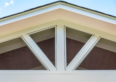 Porch renovation detail of trim work and custom screening for gable pediment design.
