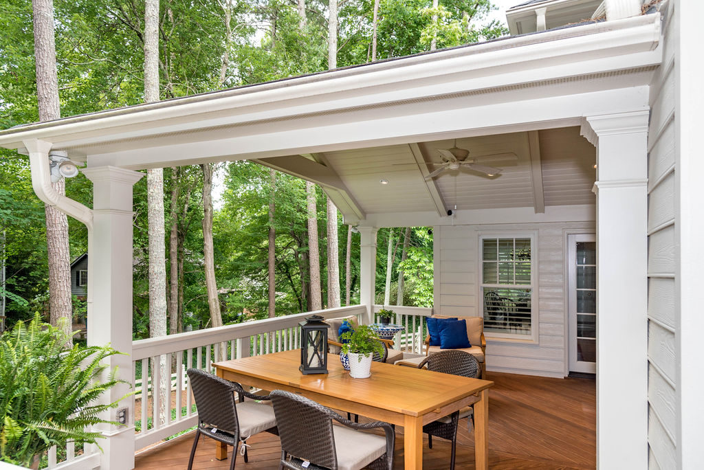 Porch renovation with view of how roof ties into house, with crowned corner posts, vaulted tongue and groove ceiling, recessed lighting, and exposed beams.