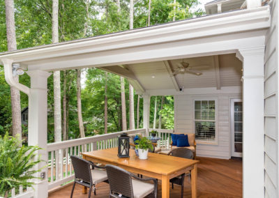 Porch renovation with view of how roof ties into house, with crowned corner posts, vaulted tongue and groove ceiling, recessed lighting, and exposed beams.