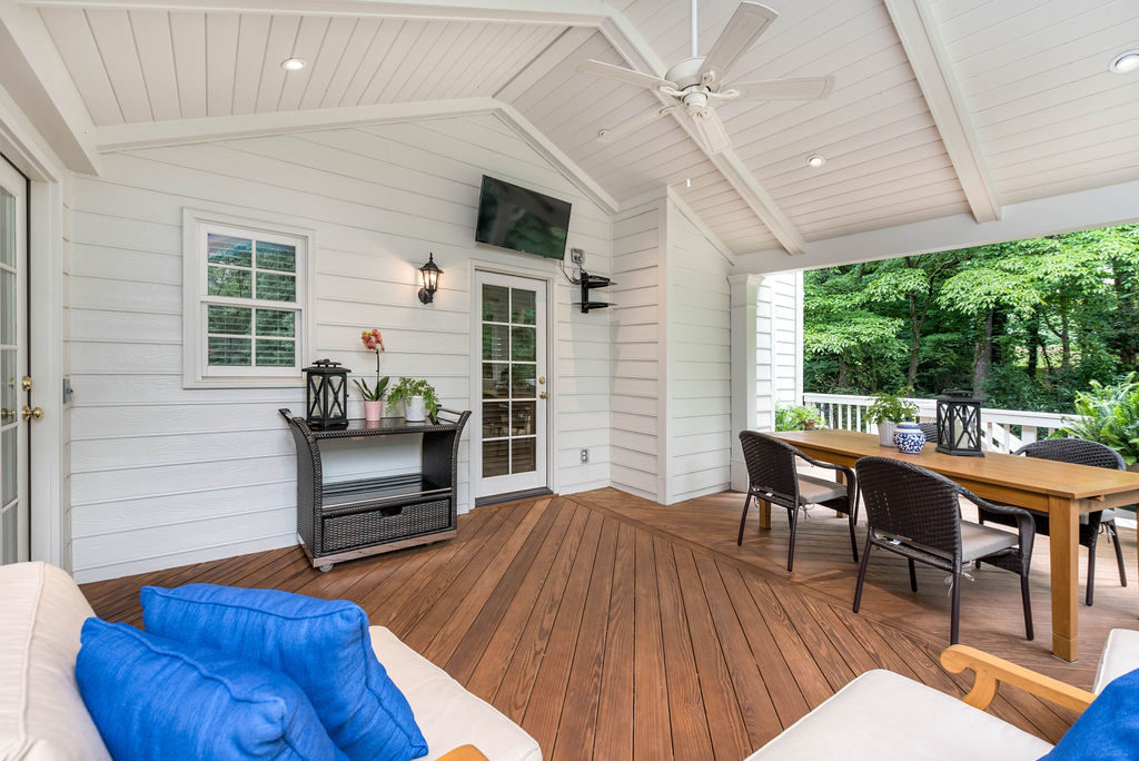 Porch renovation with view of how roof ties into house, with crowned corner posts, vaulted tongue and groove ceiling, recessed lighting, exposed beams, and outdoor TV hookup..