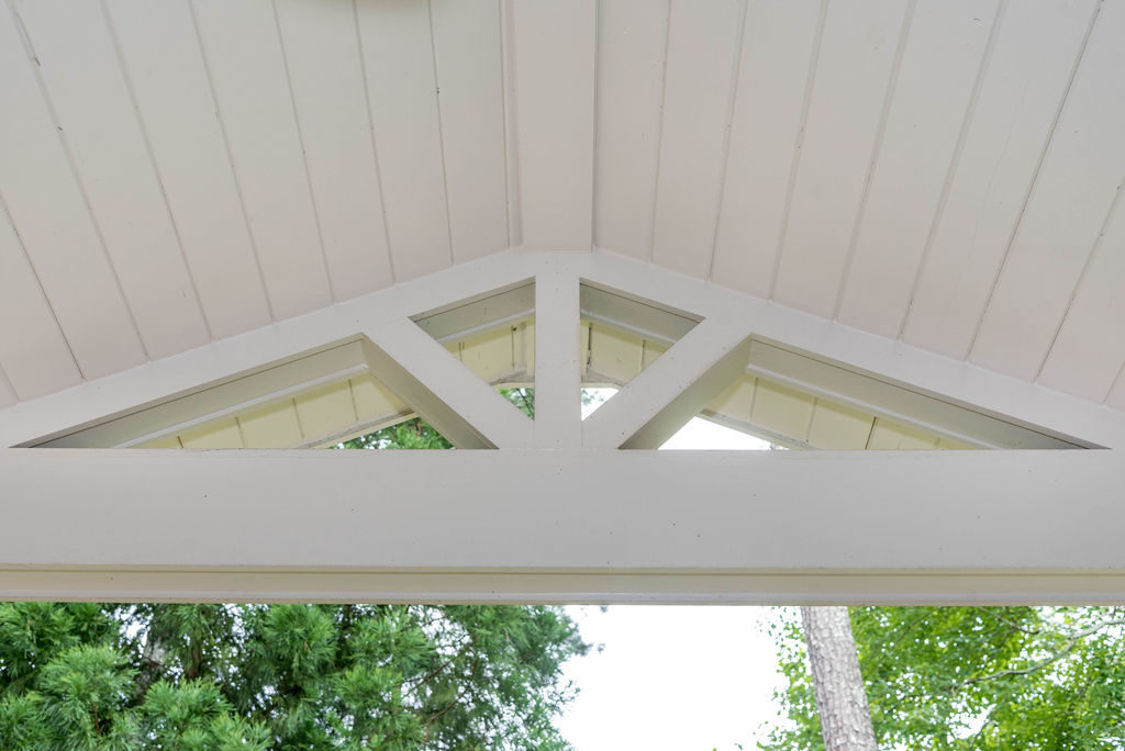 Porch renovation detail of gable pediment design, tongue and groove vaulted ceiling, and beam.