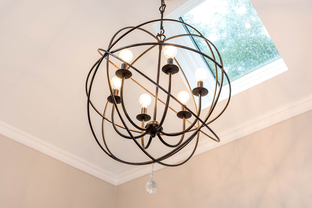 Six-bulb pendant light, with metal-hooped sphere and antique copper finish.