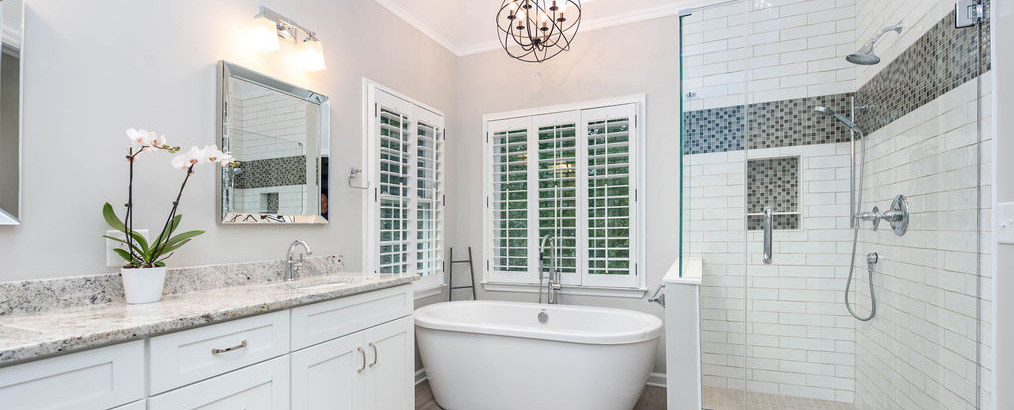 Master bathroom renovation with freestanding tub, glass-walled shower, granite vanity top, corner windows and skylight.